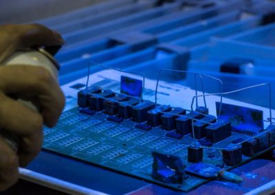 A PCB Board Manufacturer Spraying a Protective Coating to the PCB Circuit Board